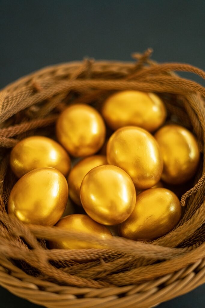 Close-up of golden eggs elegantly arranged in a woven basket, symbolizing luxury and Easter themes.