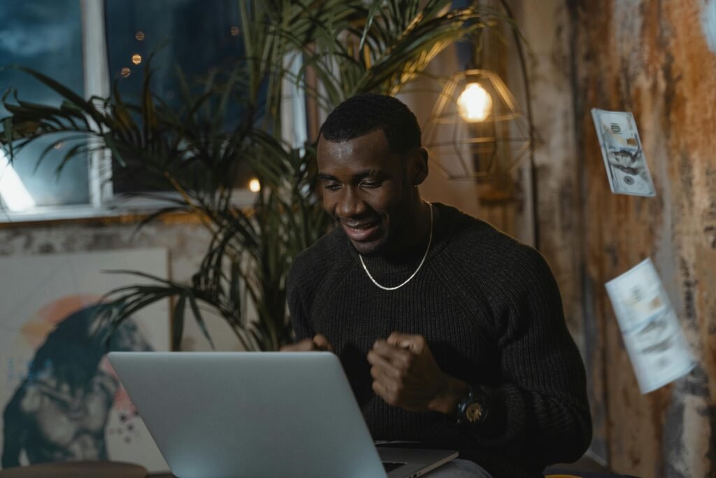 Excited man at home office celebrating success during an online course.